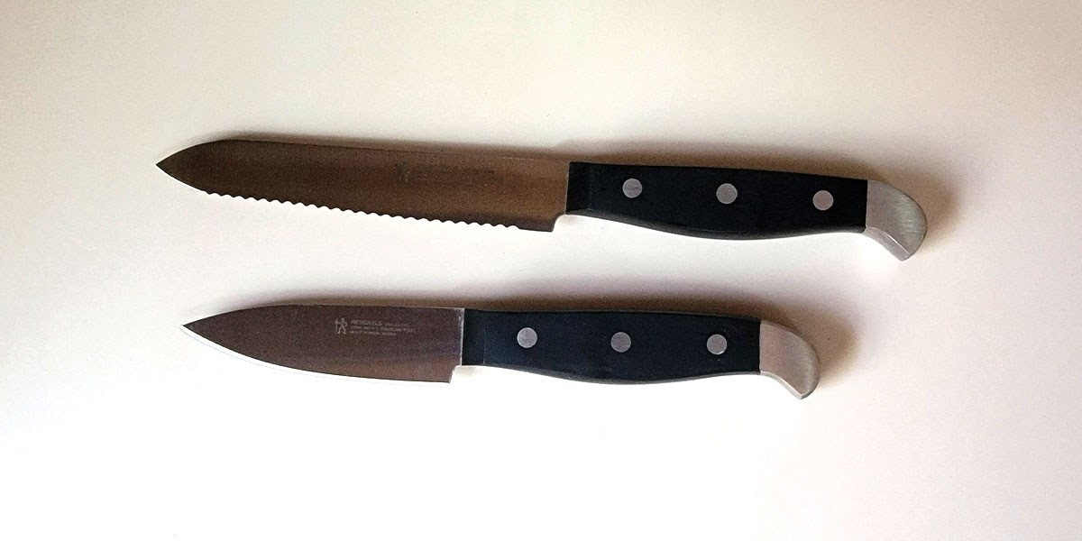Two Henckels Premium Quality Knives with black handles displayed oncounter Two Henckels Premium Quality Knives with black handles displayed oncounter