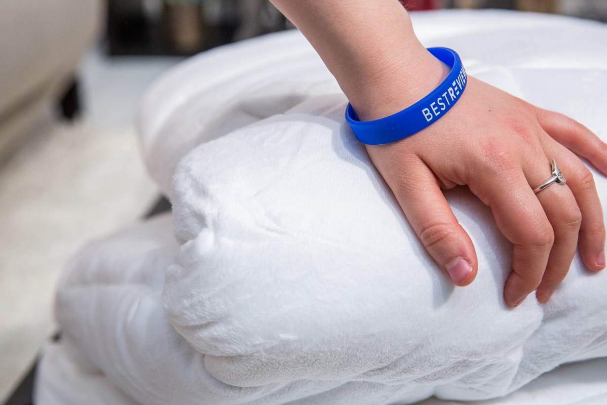 a hand on top of a white comforter