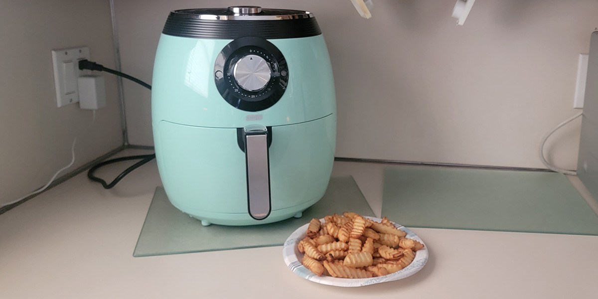 Aqua air fryer on counter with plate of fries in front of it Aqua air fryer on counter with plate of fries in front of it