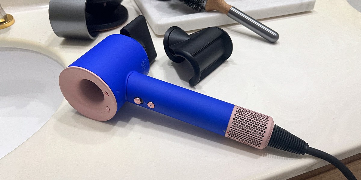 Blue Dyson Supersonic Hair Dryer and Accessories on Bathroom Counter
