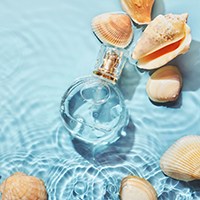 cologne submerged in water surrounded by shells