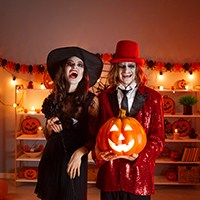 a woman in a witch costume and a man in a red suit and red hat costume