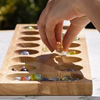 Mancala board with hand dropping stones